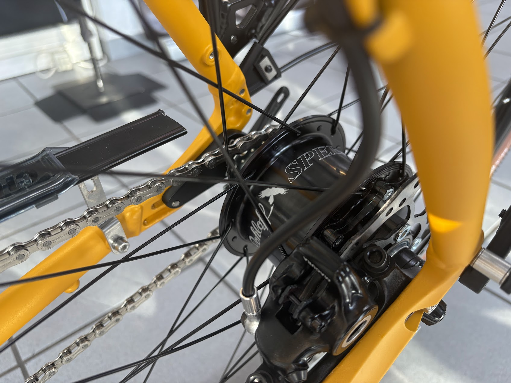 Rohloff-Nabenschaltung mit Kette und Scheibenbremse am gelben Fahrradrahmen
